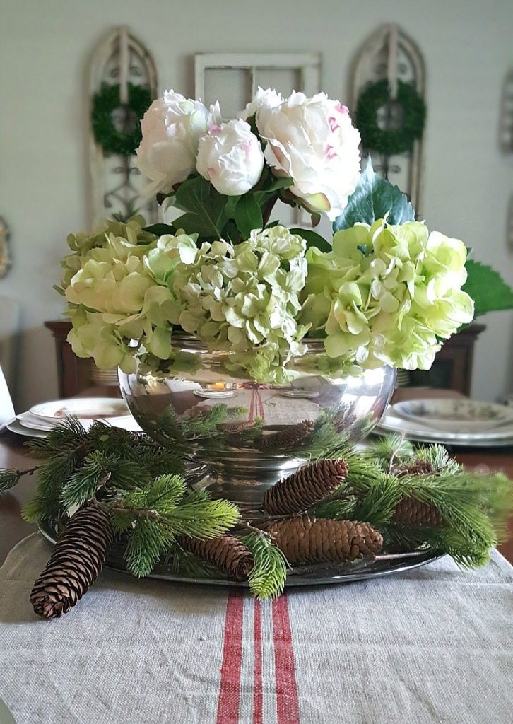 Dining room floral center piece with pine cones, evergreen in an antique punch bowl for an inspired Christmas decor theme