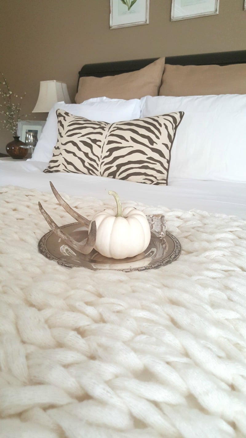 beautiful cream colored arm knit blanket creates luxurious bed