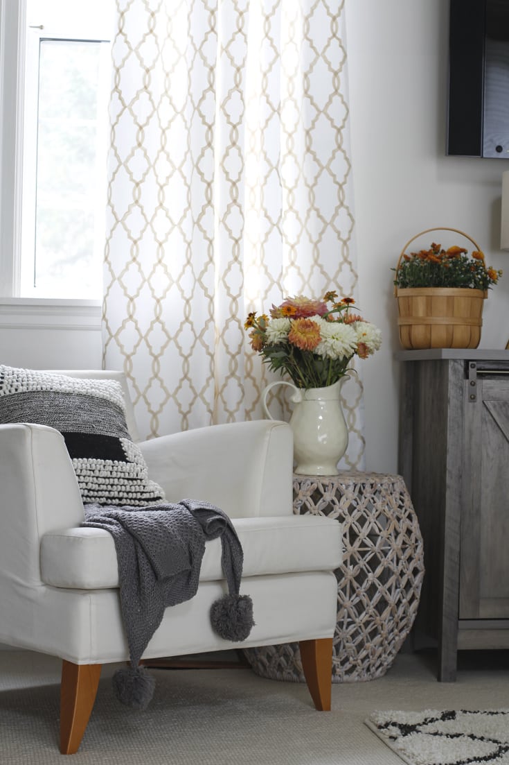 affordable cozy inviting decor and seating with pom pom throw and florals