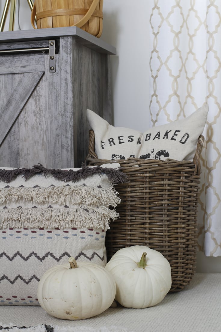 Affordable fall decor with wicker baskets and pillows and pumpkins
