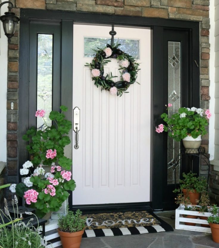 pink door and pink flowers with seasonal wreath and black and white mat for spring
