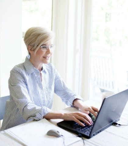 woman is happy working on laptop because she understands winning Instagram strategies for success.