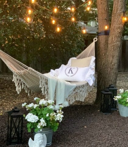 backyard hammock refresh with flowers and string lights