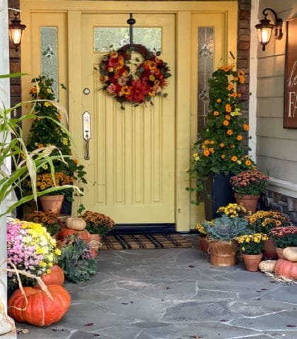 Gold painted front door with mums and flowers decorated for fall