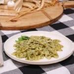 Grandma's homemade basil pesto recipe with farfalle pasta on black and white tablecloth