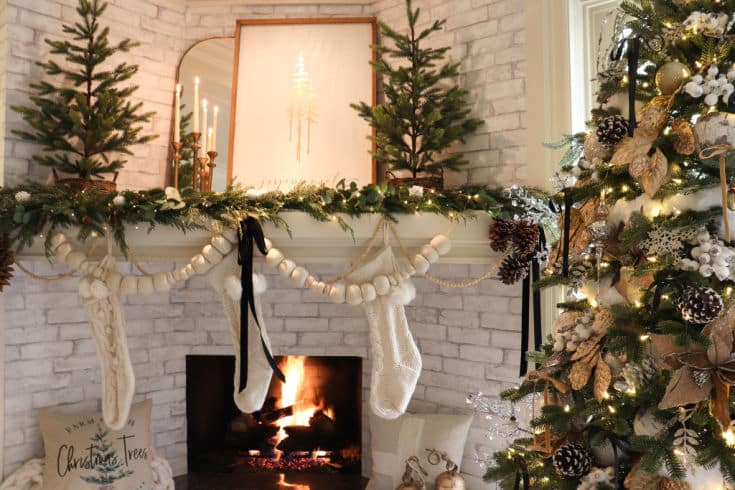 Christmas mantel decorated with mirror and farmhouse sign and evergreen trees