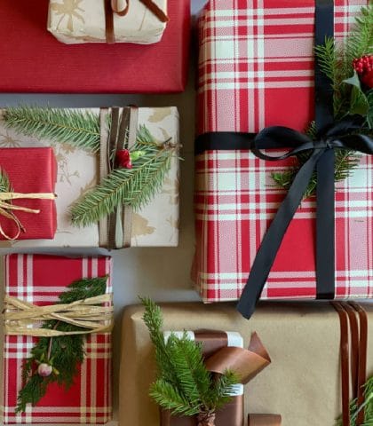 Christmas gift wrap with ribbon and evergreen sprigs and simple floral and natural elements