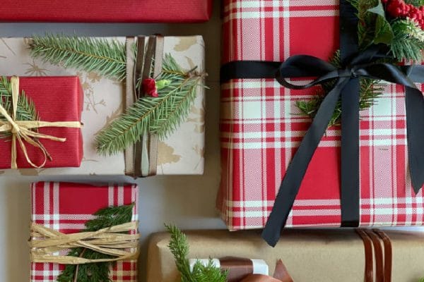 Christmas gift wrap with ribbon and evergreen sprigs and simple floral and natural elements