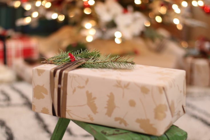 Christmas Gift wrap with velvet ribbon in front of Christmas tree