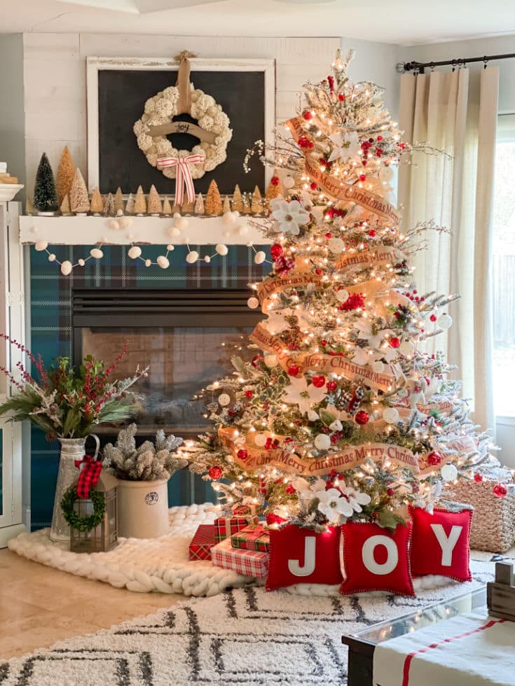 Red and green festive Christmas tree and mantel decor with tarten fireplace surround