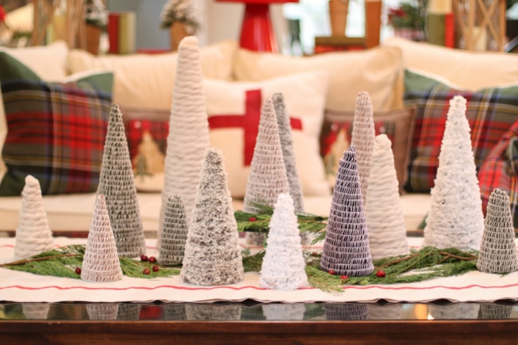 Mini Christmas trees made of different types of yarn displayed on coffee table