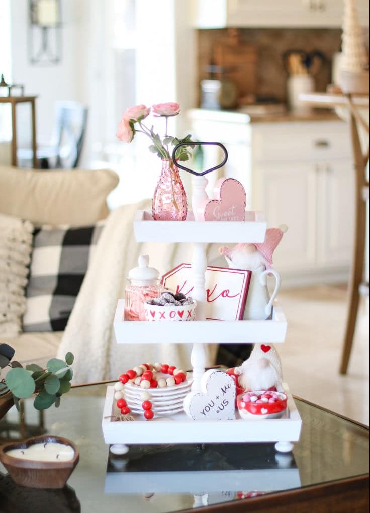 coffee table tiered tray decorated with Valentines day decor in red and pink on white wood 3 tiered tray