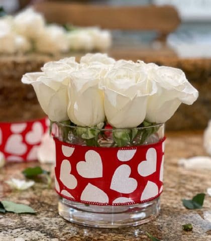 white roses in simple vase with red heart ribbon for Valentines Day gift idea