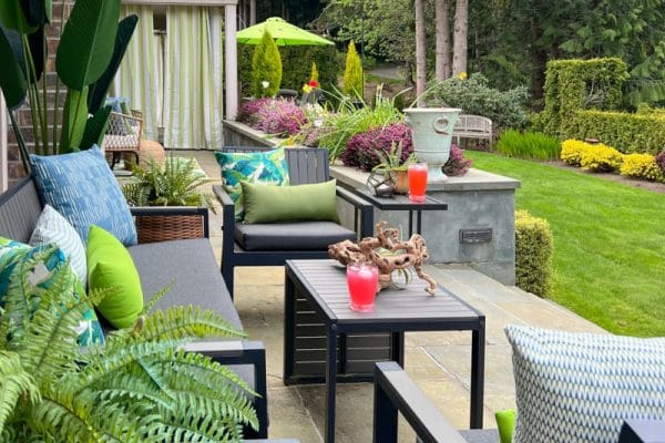 backyard makeover looks fresh and inviting with pops of color from new pillows rugs and curtains in budget friendly patterns