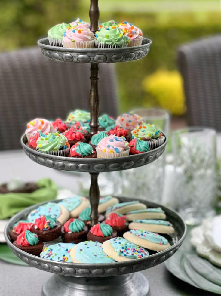 Three tiered tray displays beautiful cookies and colorful decorated baked goods